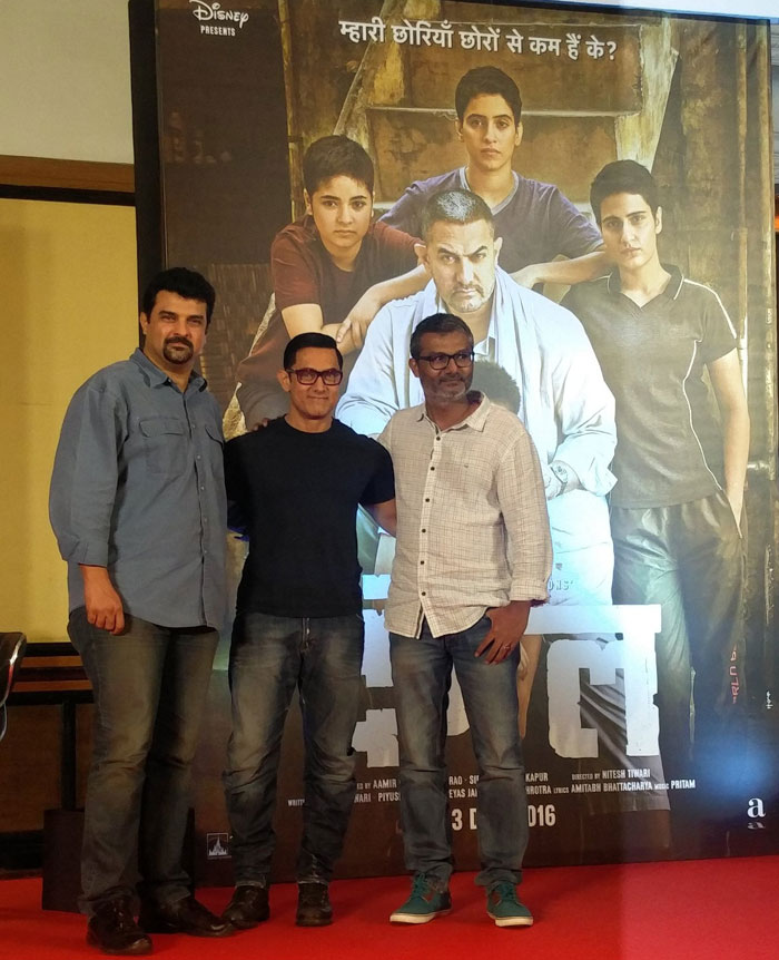 Aamir Khan, Nitesh Tiwari Siddharth Roy Kapur strike a pose against the Dangal Poster